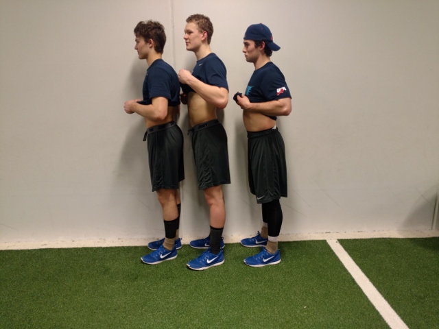 NTDP U18 Team Captains. Note the lumbar extension and anterior pelvic tilt.  Also observe how the back of the knees are flat because the knee joint is hyperextending. This is a result of excessive len